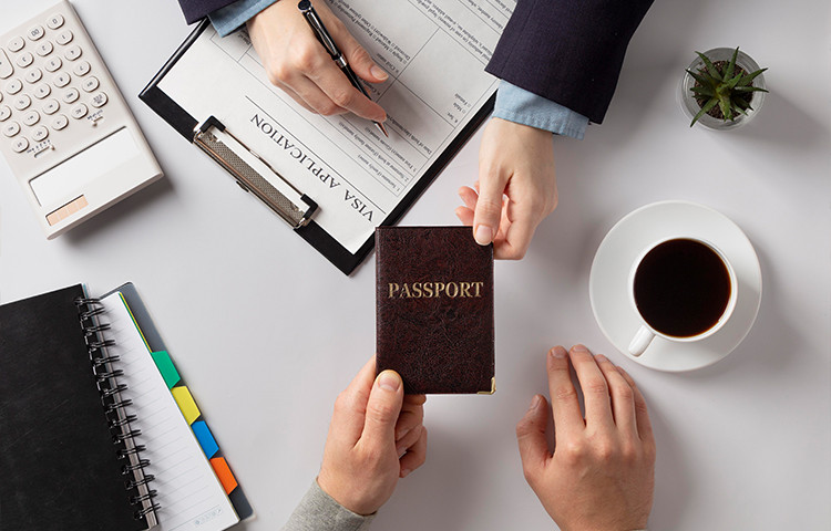Visa interview - visa application on table & passport in man's hand - Schengen visa & immigration